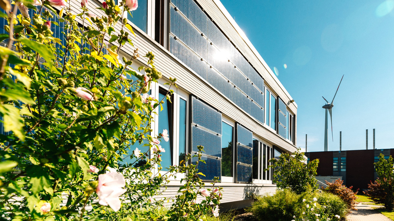 Ansicht der Gebäudefront in Seehausen mit Solarpanels und vielen blühenden Blumen